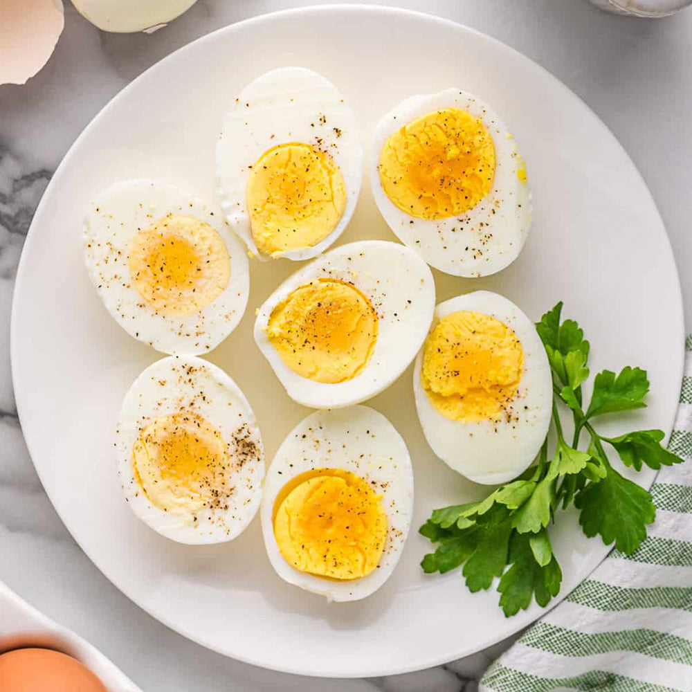 Sliced hard-boiled eggs on a white plate with a green napkin