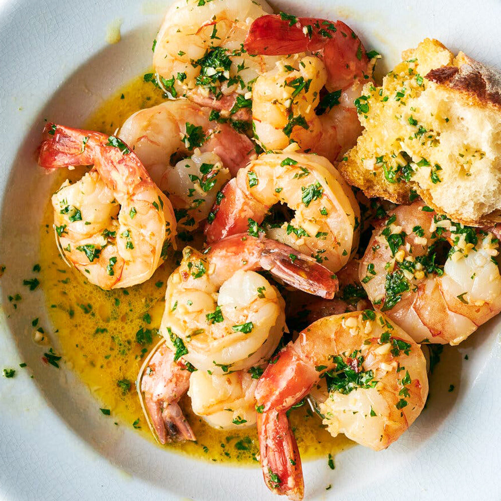 Baked shrimp with herbs on a white plate
