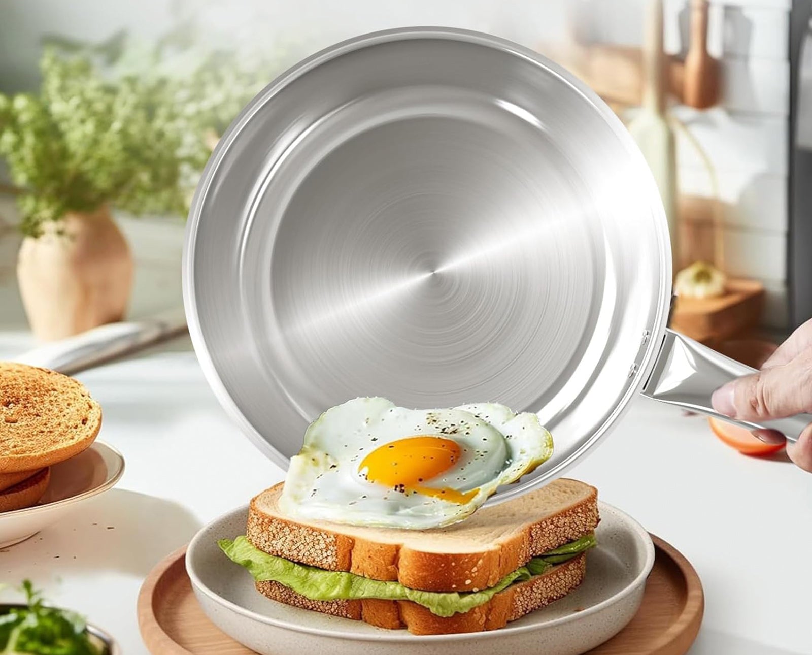 Sunhouse Silver frying pan being used to cook an egg on a sandwich in a kitchen setting.