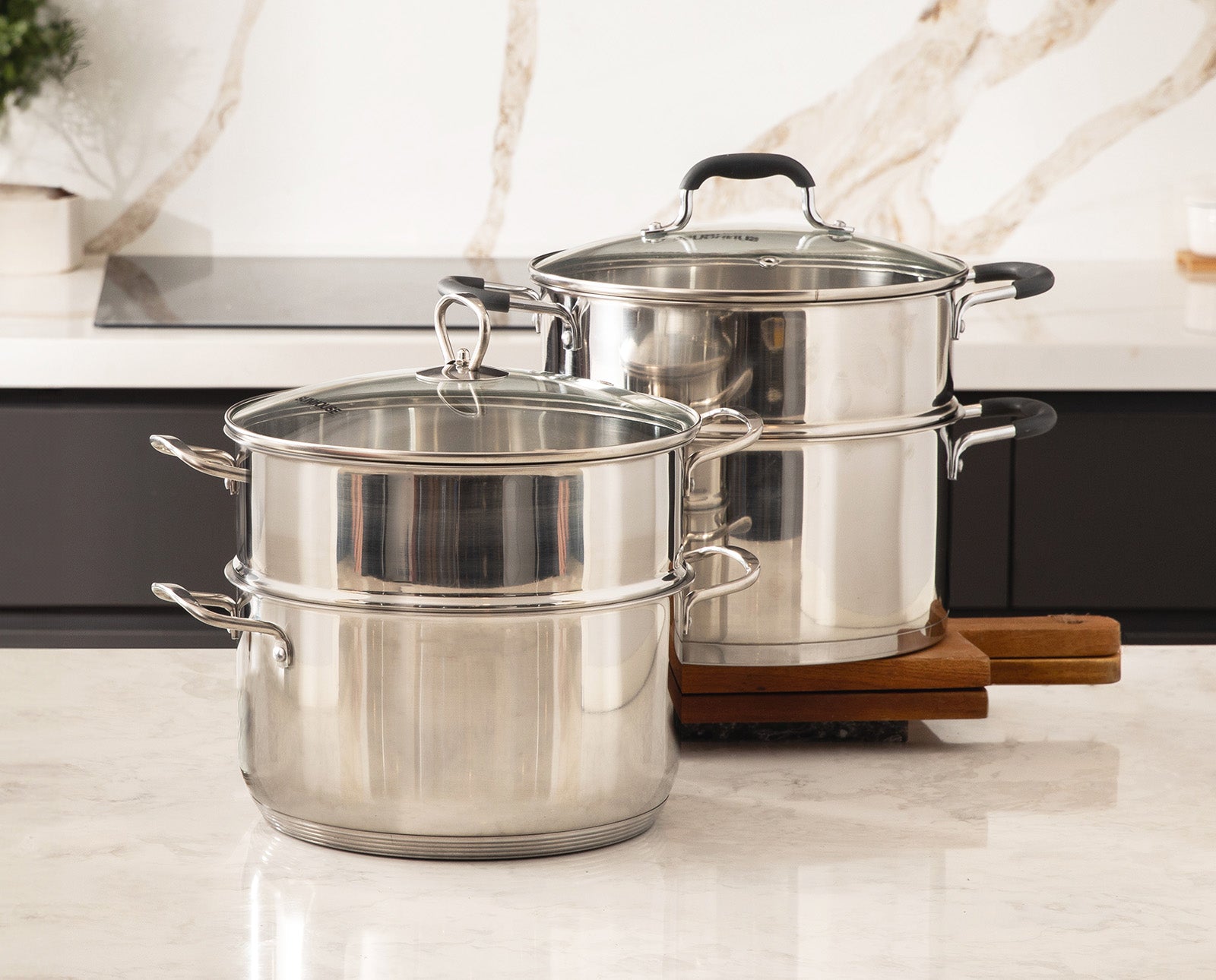 Sunhouse Set of stainless steel pots with lids on a kitchen counter