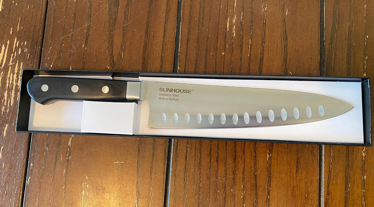 Chef's knife with 'Sunhouse' branding on a wooden surface