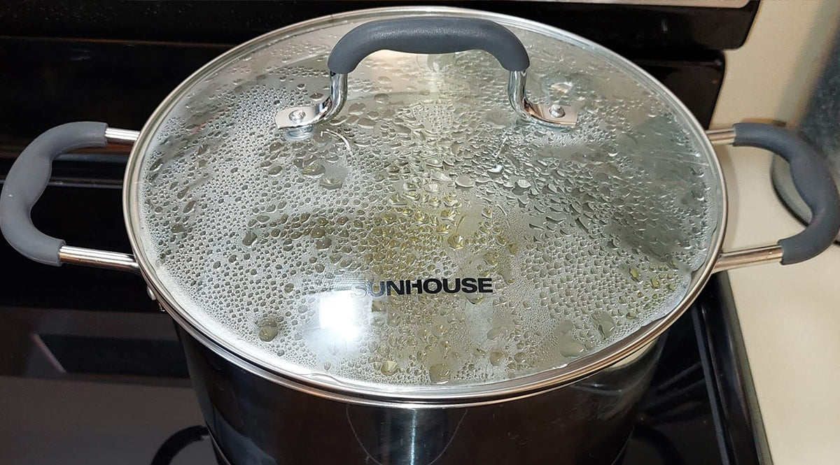 Stovetop with a pot covered by a lid branded 'Sunhouse'.