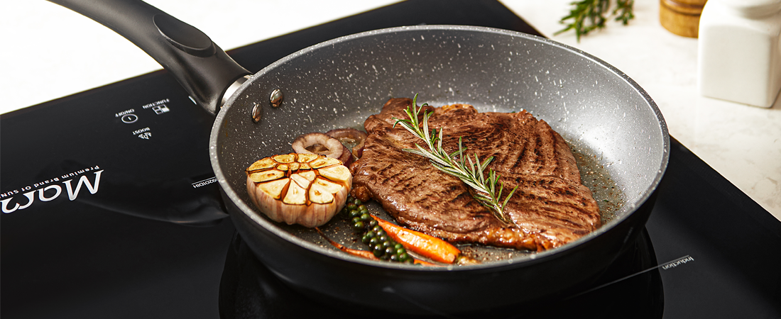 Steak being cooked in a pan on an induction cooktop with visible brand Sunhouse.